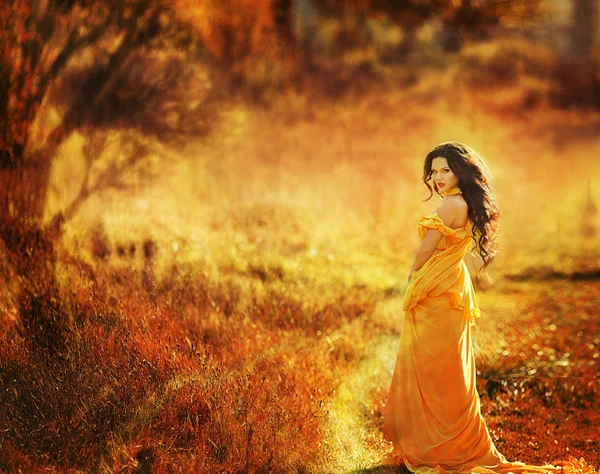 Young beautiful girl in a yellow dress in the woods