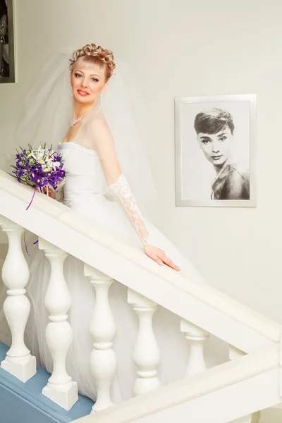 Beautiful bride with elegant white wedding dress with hand to head