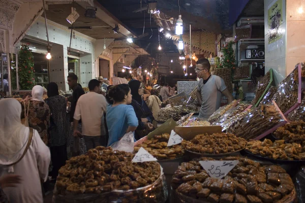 Vendors and customers stand by sweets stall