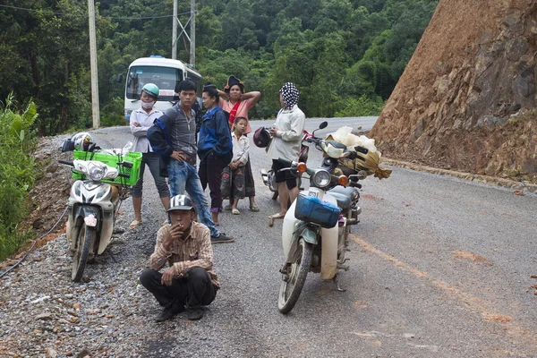 People wait for clearing a road after landslide