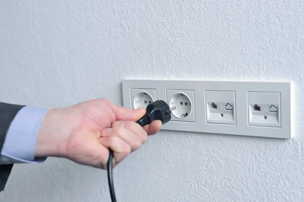 Humans hand with power cord