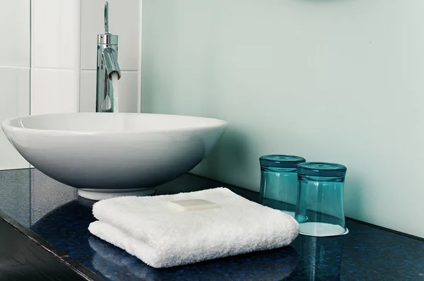 Bathroom sink counter towels water glass blue