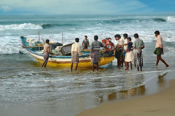Poor Indian fishermen pushed the boat for water, Orissa, India