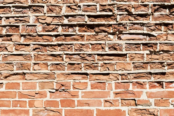 Background of old vintage crumbling brick wall on bright sunny d