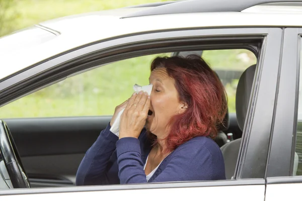 Sneezing woman in the car