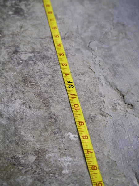 Construction Measuring Tape on grunge concrete