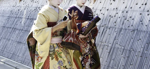 Geishas walking by an old street