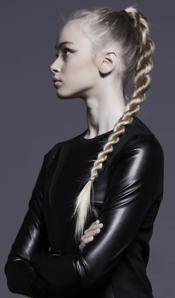 Studio shot of woman in leather dress with long hair. Profile