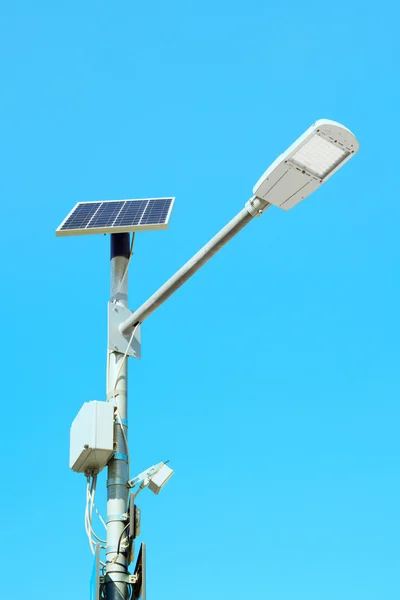 Solar panel powered street lamp on blue sky background