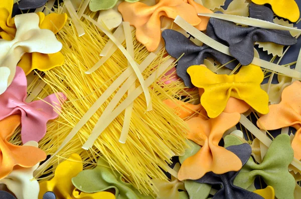 Various uncooked pasta as background