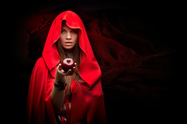 Beautiful woman with red cloak holding apple