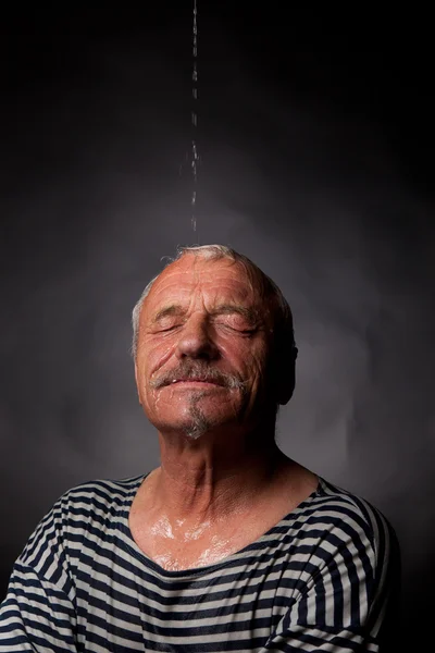 A wet man on whom pours water