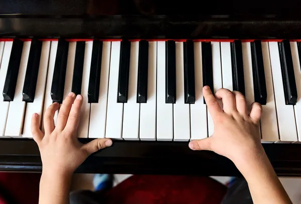 Child\'s hands playing the piano