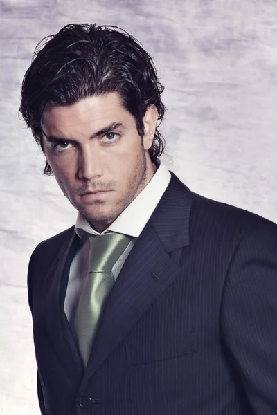 Elegant and stylish male model in black dress and green tie