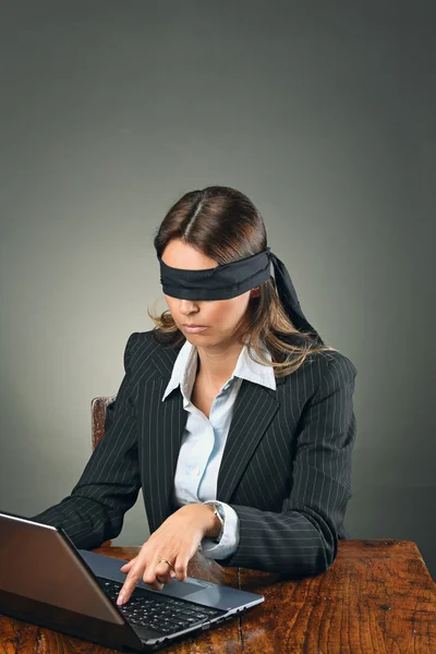 Blindfolded business woman with laptop