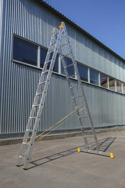 Step-ladder at warehouse wall
