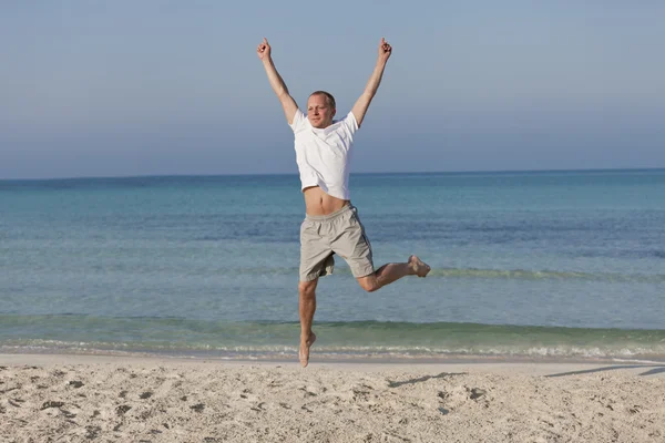 Cheerful man jumping on the beach laughing Landscape