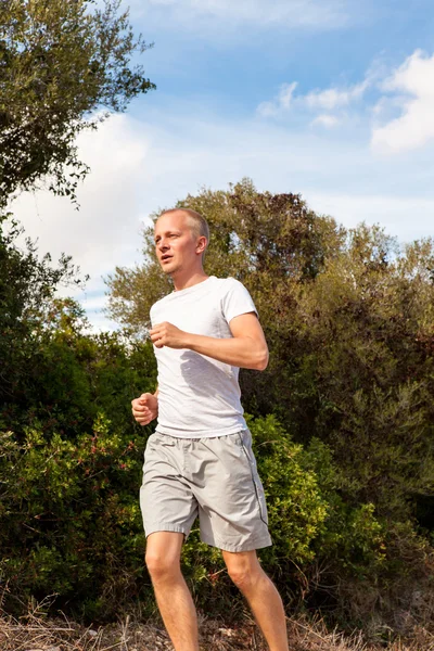 Athletic man runner jogging in nature outdoor