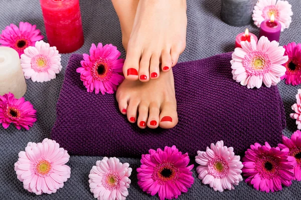 Bare feet of a woman surrounded by flowers