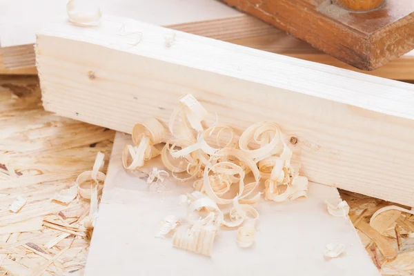 Handheld wood plane with wood shavings