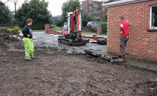 A mini digger excavating a driveway