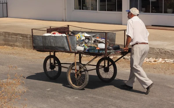 An old turkish man pushing his three wheeled cart