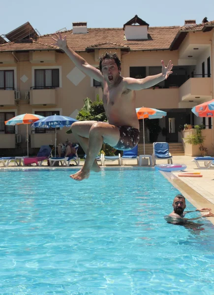 A young man jumping into a swimming pool