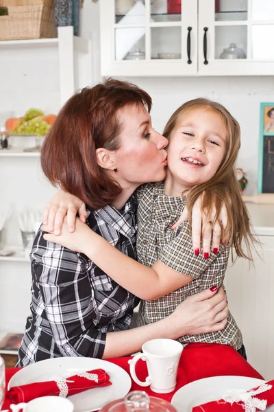 Mother embraces and kisses the daughter