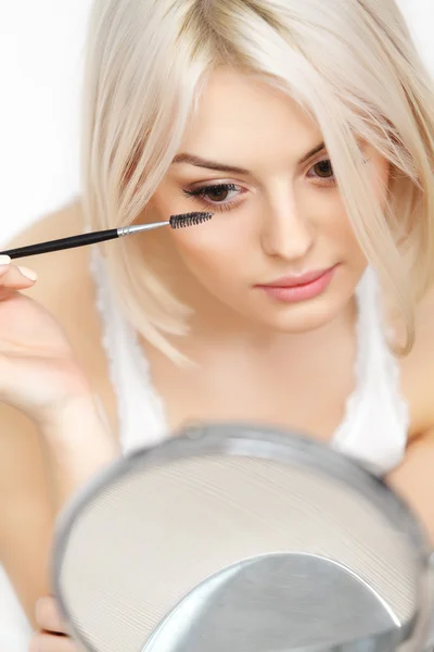 Woman applying Mascara on Eyelashes