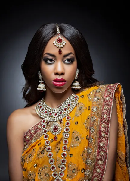 Young Indian woman in traditional clothing with bridal makeup and jewelry