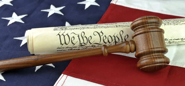 US constitution with judge\'s gavel over American flag background