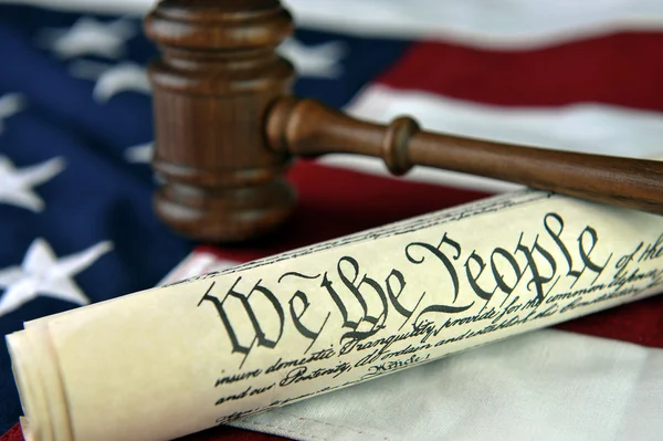 US constitution with judge\'s gavel over American flag background