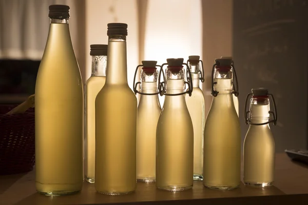 Bottles filled with elderflower syrup against the light