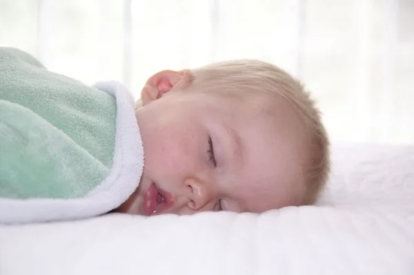 Little toddler boy is sleeping under the blanket