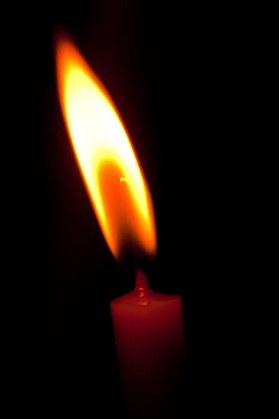 Closeup of burning candle isolated on black background