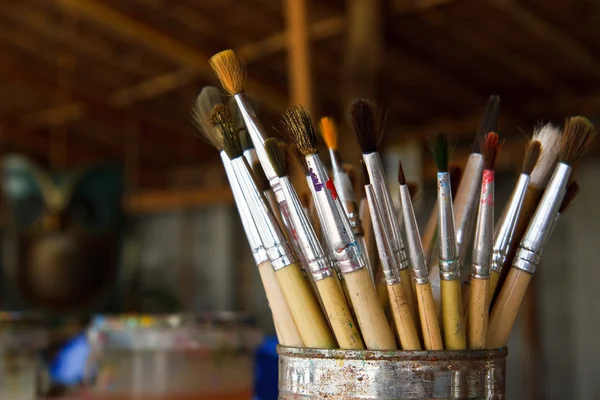 Old paint brushes in cans.