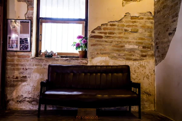 Black sofa in the old brick walls.