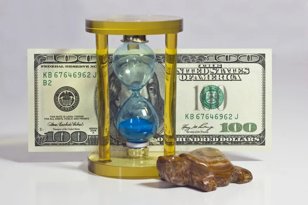 Glass hourglass and money