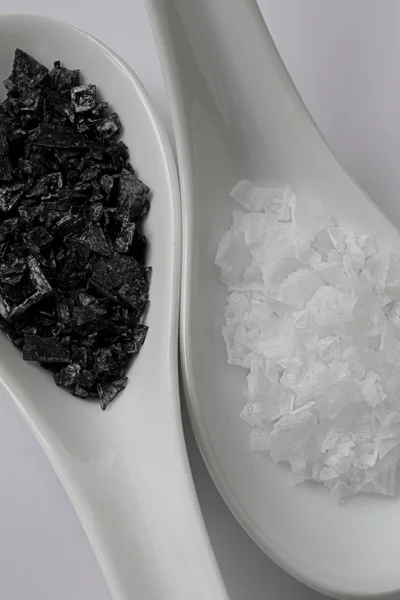 Close of of Black and White Natural Sea Salt on Spoons