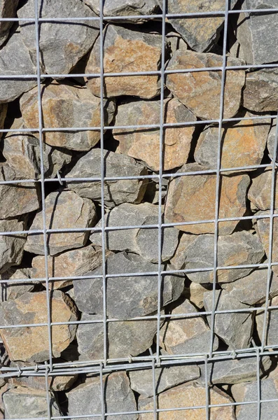 Wire mesh and stone retaining wall