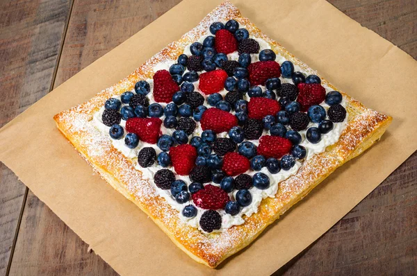 Fresh berry tart with cream and sugar