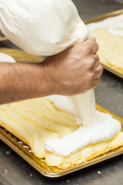 Chef hands preparing cream cake