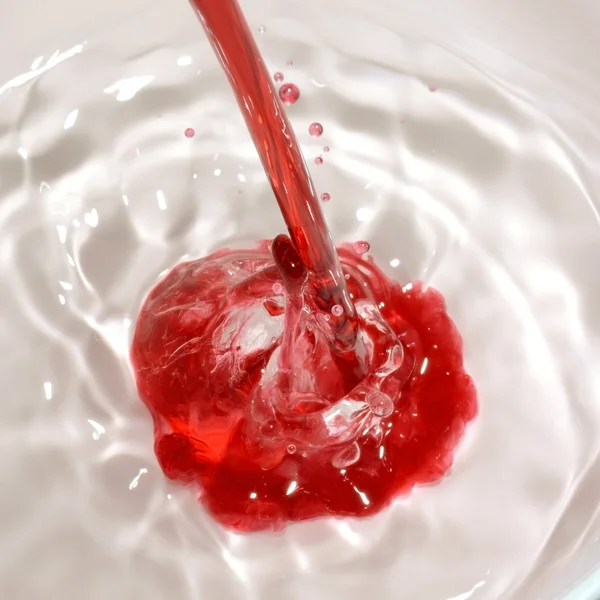 Red liquid poured into clear liquid