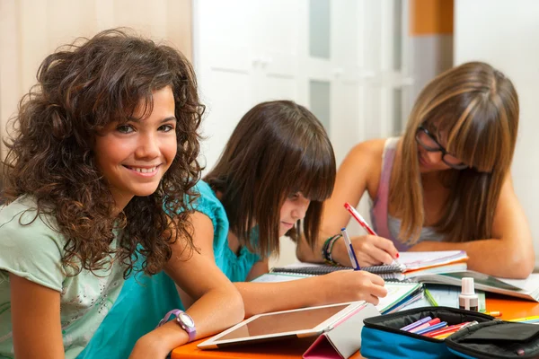 Portrait of teenage girl with friends doing homework.