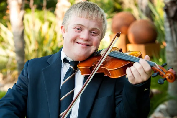 Smiling handicapped boy playing his violin.