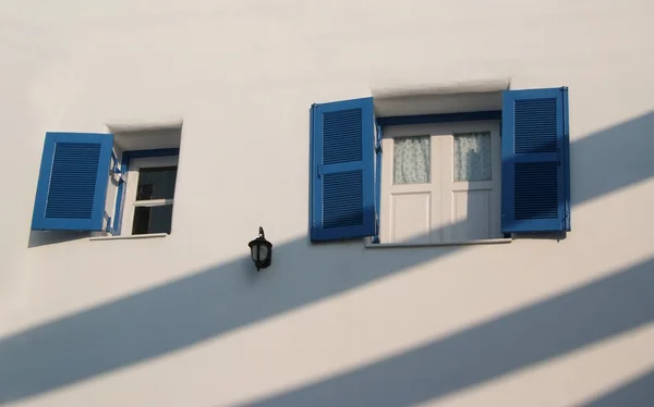 Light and shadow on the blue window and the white wall