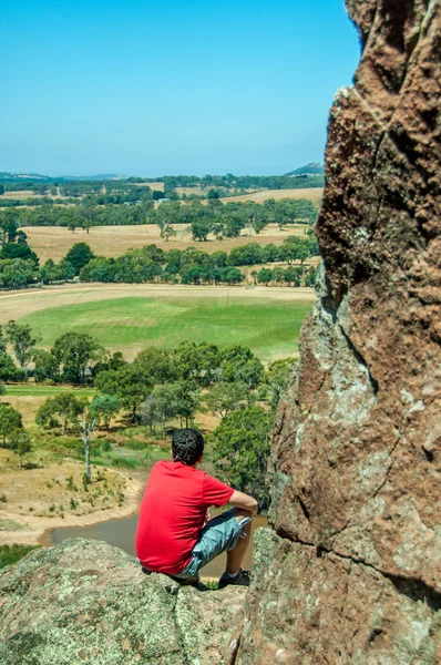 Man staring into distant horizon from mountain edge