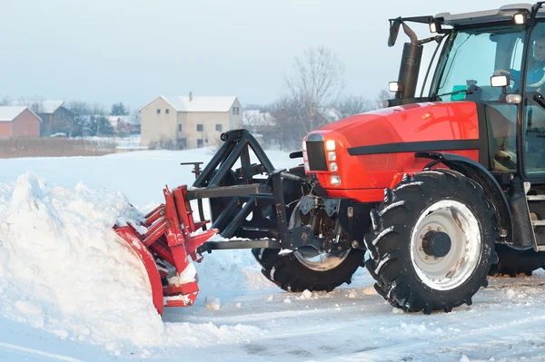 Tractor cleaning snow
