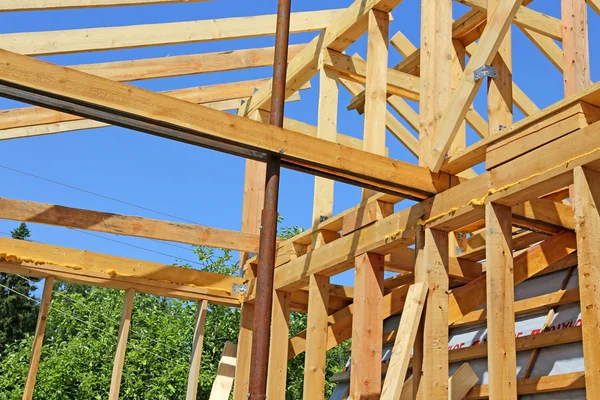 Installation of wooden beams at construction of frame house