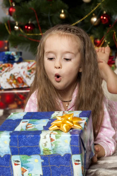 The girl with a gift under the Christmas tree